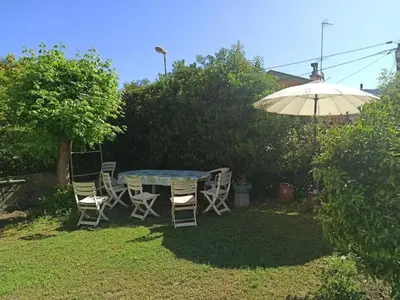 a table and chairs and an umbrella in a yard at Villa tres proche du centre ville in Nice