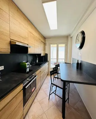 a kitchen with a table and a dining room at The NICE - 3 rooms, 3air cond, 3TV, 3fans, 2 wc, WIfi everywhere 5min aeroport, train, beach, 1min tram, 15 min centre, port, parking possible in Nice