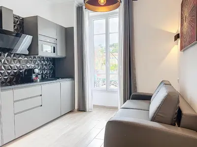 a living room with a couch and a kitchen at Central Beautifull Delille Flat in Nice