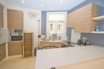 a kitchen with wooden cabinets and a white counter top at Promenade des Anglais - Sea View 2bdr in Nice