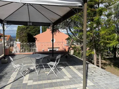 a patio with two chairs and an umbrella at Chambre d'hôtes duplex Le petit mas niçois de la Villa rose in Nice