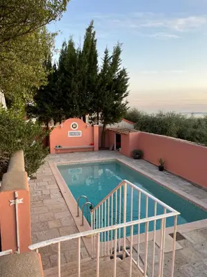 a swimming pool with a staircase next to a house at Chambre d'hôtes duplex Le petit mas niçois de la Villa rose in Nice
