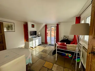 a bedroom with a bed and a couch and a lamp at Chambre d'hôtes duplex Le petit mas niçois de la Villa rose in Nice
