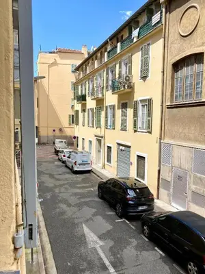 a street with cars parked in front of a building at Petit cocon en duplex - Centre-ville & plage à 2 minutes in Nice