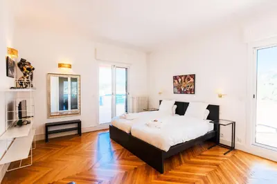 a bedroom with a bed and a large window at LE CAP DE NICE VI4150 by RIVIERA HOLIDAY HOMES in Nice