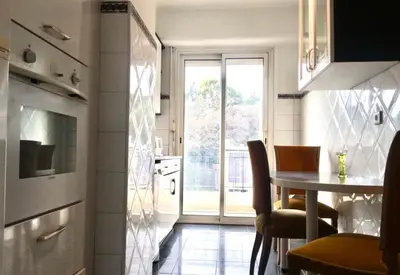 a small kitchen with a table and a window at Grand appartement proche Promenade in Nice