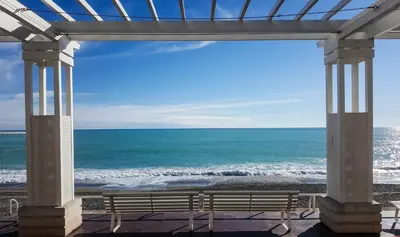 a bench on the beach looking out at the ocean at Très joli loft au cœur de Nice in Nice