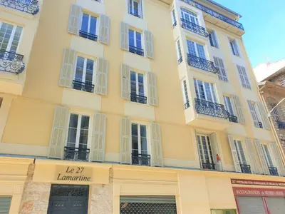 a large yellow building with white windows and balconies at Lamartine hypercentre 503 in Nice