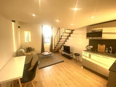 a room with a kitchen and a living room with a staircase at Lamartine hypercentre 503 in Nice