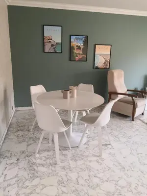 a dining room with a white table and chairs at Grand 2 pièces à 4mns de la plage in Cagnes-sur-Mer