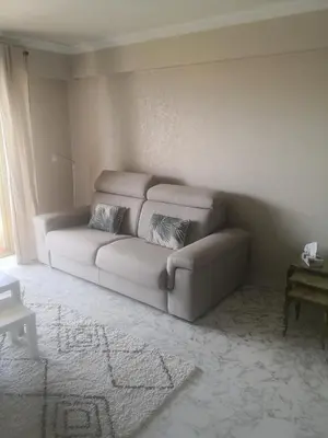 a living room with a couch in the corner at Grand 2 pièces à 4mns de la plage in Cagnes-sur-Mer
