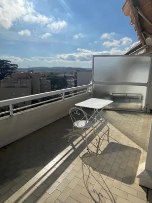 a balcony with a table and chairs on a roof at PENTHOUSE DUPLEX T3 SUNSEA in Cagnes-sur-Mer