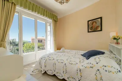 a bedroom with a bed and a large window at Maison Bianchi - Villa Saint Pierre de Feric in Nice
