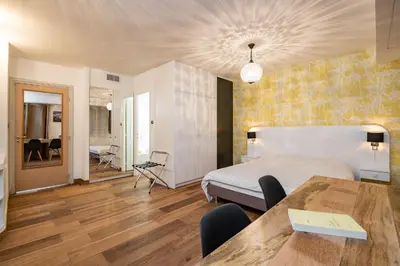 a bedroom with a bed and a table in a room at Chauvain Résidence in Nice