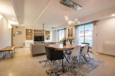a dining room and living room with a table and chairs at Chauvain Résidence in Nice