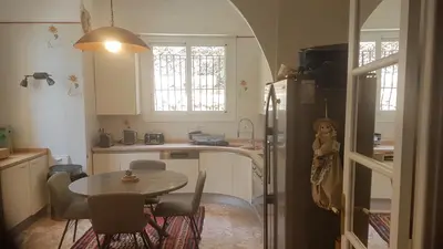 a kitchen with a table and a refrigerator and a table and chairs at Roc Maria Lucia in Nice
