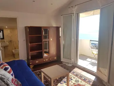 a living room with a blue couch and a sliding glass door at Roc Maria Lucia in Nice