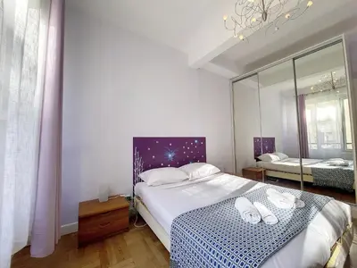 a bedroom with a large bed and a mirror at Nestor&Jeeves - BEAUSOLEIL - Central - tres proche mer in Nice