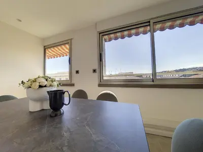 a dining room with a table with a vase of flowers on it at Nestor&Jeeves - BELLE ETOILE - Central - Premium in Nice