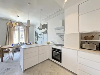 a white kitchen with white cabinets and a table at Nestor&Jeeves - SEAHORSE - Central - Proche mer in Nice