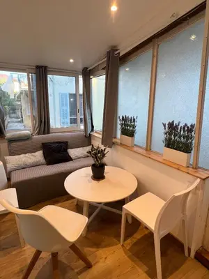 a living room with a couch and a table and chairs at appartement nice in Nice