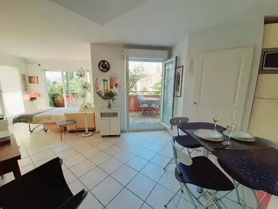 a living room with a bed and a table and chairs at studio joli in Nice