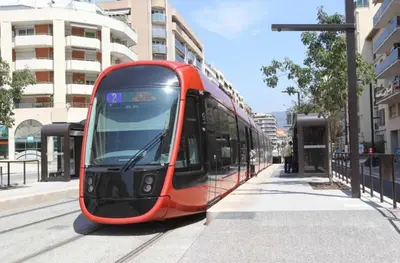 a red tram on a street in a city at studio joli in Nice