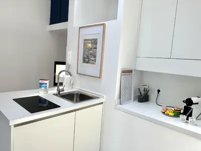 a white kitchen with a sink and a counter at MAISON BLEUE AP4362 By Riviera Holiday Homes in Villefranche-sur-Mer