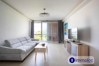 a living room with a couch and a tv at Air-conditioned studio 5 minutes from the beach and shops in Cros-de-Cagnes