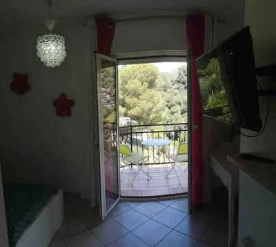 an open door to a balcony with a table and chairs at Villa avec piscine et vue magnifique sur Nice in Nice