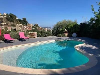 a large pool with blue water in a yard at Villa avec piscine et vue magnifique sur Nice in Nice