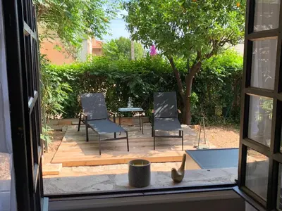 a window view of a patio with chairs and a table at Appartement 1pièce avec jardin dans Mas de Caractère in Saint-Laurent-du-Var