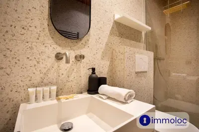 a bathroom with a white sink and a mirror at Air-conditioned apartment in Old Nice in Nice