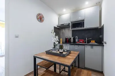 a kitchen with a wooden table in a room at 1 Bdr Large Terrace in Nice