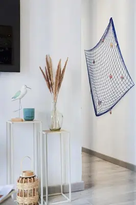 two tables with vases and a basket on a wall at Appartement 2 pieces in Nice
