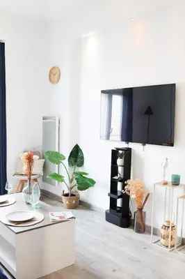 a living room with a white table and plants at Appartement 2 pieces in Nice