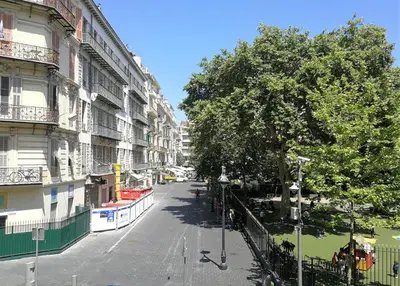 an empty city street with a tree and buildings at Appartement 110m2 Nice plein centre in Nice