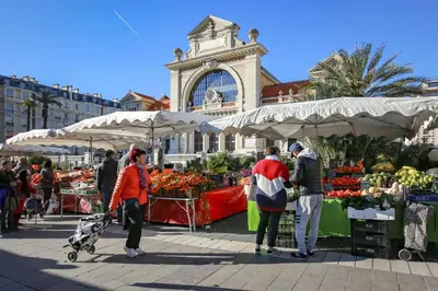 a group of people standing around a market with fruits and vegetables at Cosy appartement en plein coeur de la libération in Nice