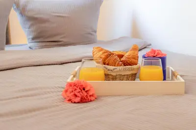 a tray with a basket of bread and two glasses of orange juice at BEAUTIFUL apartment , beach 3 min walk , free parking, near Negresco in Nice