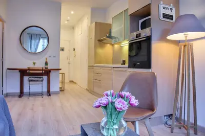 a living room with a vase of flowers on a table at BEAUTIFUL apartment , beach 3 min walk , free parking, near Negresco in Nice