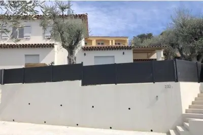 a white fence in front of a white house at Nice, Magnifique villa vue mer avec piscine in Nice