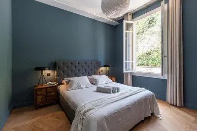 a blue bedroom with a bed and a window at MY CASA - HSAUVAN - Villa Design Swimming Pool Sea View in Saint-Jean-Cap-Ferrat