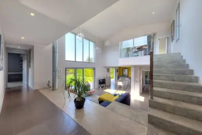 a living room with a staircase and a couch at Villa Contemporaine à Carros les plans in Carros