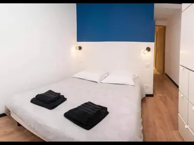 a bedroom with a white bed with two black towels on it at Charming Apartment in Nice in Nice