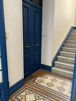 a hallway with a blue door and a staircase at Cosy Blue Nice in Nice