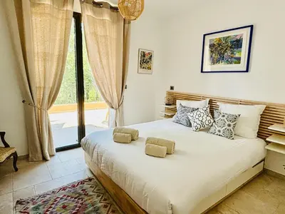 a bedroom with a large bed with a large window at Paisible et Spacieuse Villa avec 4 suites indépendantes in La Gaude