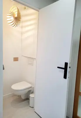 a bathroom with a white toilet and a yellow light at Studio climatisé vue imprenable wifi in Vence