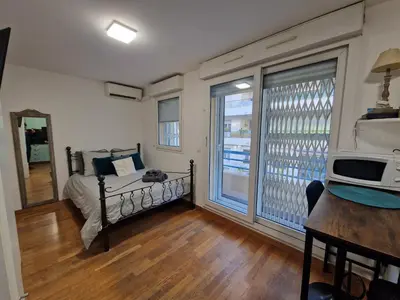 a bedroom with a bed with blue pillows and a mirror at Aya's Studio in Nice