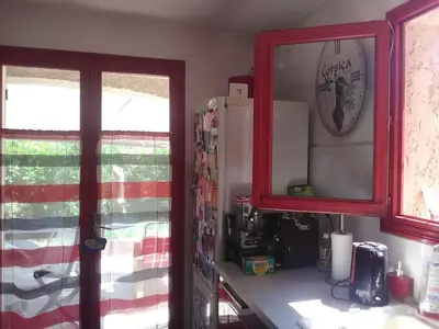 a kitchen with a red cabinet and a refrigerator at VILLA DE CHARME sur la Côte d'Azur in Tourrette-Levens