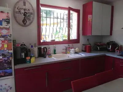 a kitchen with red cabinets and a sink and a window at VILLA DE CHARME sur la Côte d'Azur in Tourrette-Levens
